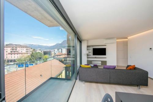 a living room with a couch and a large window at Urban Apartment Paradiso with Balcony and Parking - Happy Rentals in Paradiso