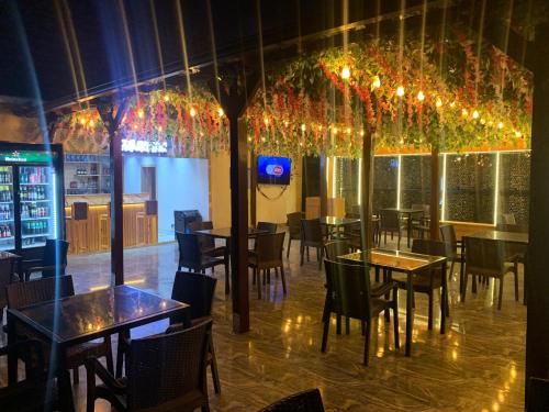 a dining room with tables and chairs and chandeliers at Perch Hotel & Suites in Lagos