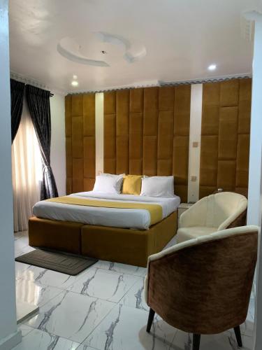 a bedroom with a large bed and a chair at Perch Hotel & Suites in Lagos
