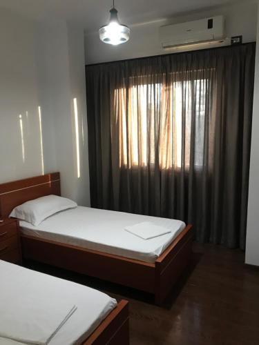 a bedroom with two twin beds and a window at Glaunkel in Ksamil