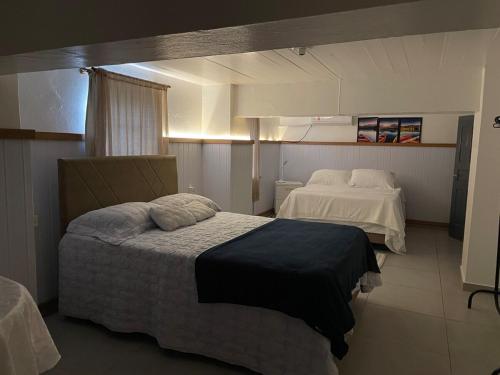 a hotel room with two beds in a room at Espaço da Mariah in Arroio do Meio