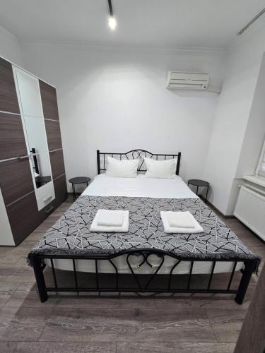 a bedroom with a bed with two towels on it at Small House ApartHotel in Chişinău