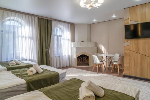 a hotel room with two beds and a fireplace at Tashrabat Hotel in Karakol