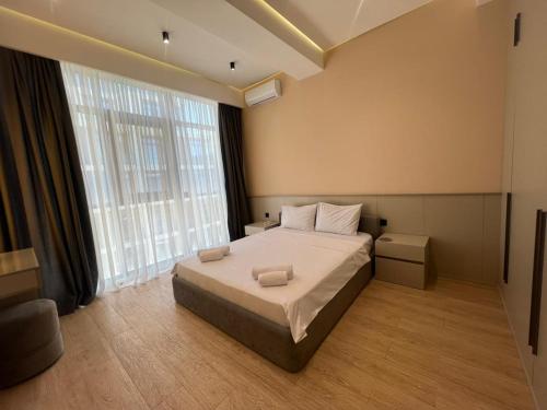 a bedroom with a large bed and a large window at Sea Breeze Polo in Nardaran