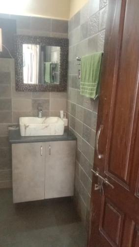a bathroom with a sink and a mirror at The Aalayam in Mukteshwar