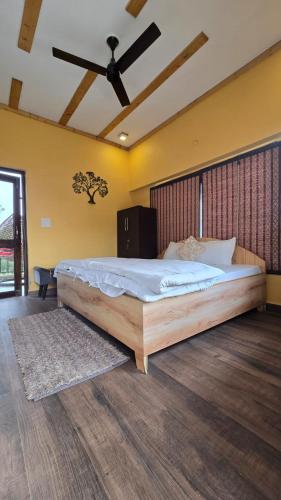 a bedroom with a large bed with a ceiling fan at The Aalayam in Mukteshwar