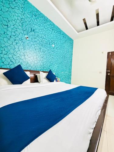 a bedroom with a bed with a blue wall at Hotel Rs Inn - 5 Mints Walk From New Delhi Railway Station And Connaught Place in New Delhi