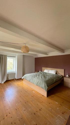 a bedroom with a large bed with a wooden floor at Villa Barkaboda in Barkaboda