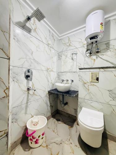 a white bathroom with a sink and a toilet at Hotel Rs Inn - 5 Mints Walk From New Delhi Railway Station And Connaught Place in New Delhi