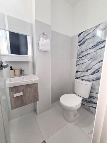 a bathroom with a white toilet and a sink at Montecarlo Hospedaje in Tacna