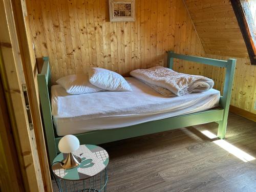 a small bedroom with a bed in a wooden room at L'Oustalou de Petit Jean in Cassaniouze