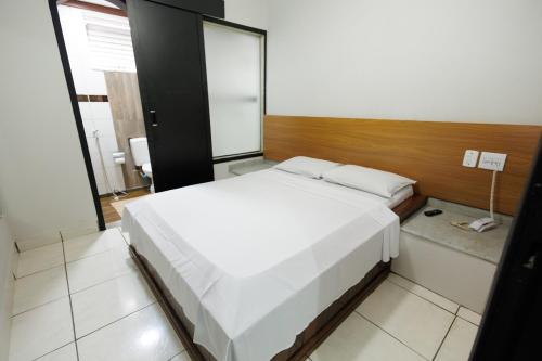 a bedroom with a large white bed in a room at Hotel Move BH in Belo Horizonte