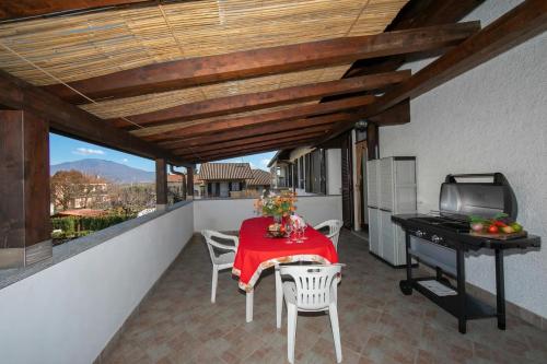 a balcony with a table and chairs and a grill at Casa Amabile in Leggiuno Salty-Water Pool - Happy Rentals in Reno Di Leggiuno
