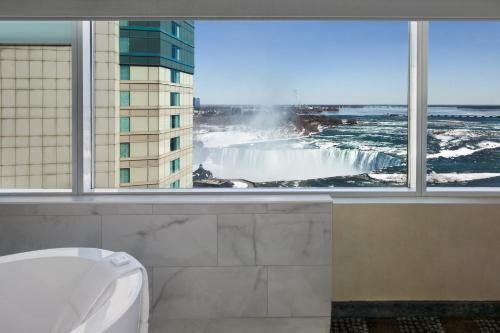 une salle de bains avec vue sur une cascade depuis une fenêtre dans l'établissement Niagara Fallsview Hotel, à Niagara Falls