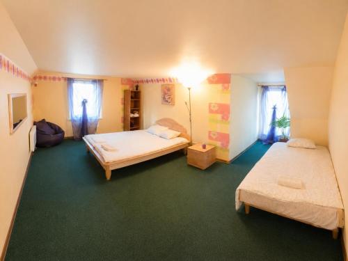 a bedroom with two beds and a room with green carpet at Neimaņu sēta Apartments in Augšlīgatne