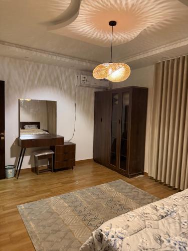 ein Schlafzimmer mit einem Bett, einem Spiegel und einem Klavier in der Unterkunft شقة غيم in Abha