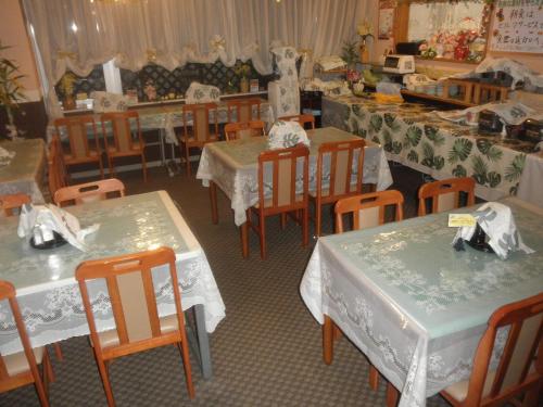 a dining room with tables and chairs with white table cloth at Business Hotel Goi Hills in Ichihara
