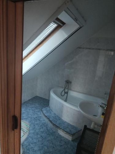 a bathroom with a bath tub and a sink at Apartmán Penzion Sigma in Dolní Žďár
