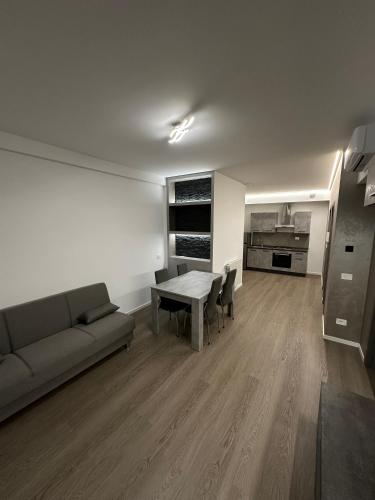 a living room with a couch and a table at Grey loft in Torvaianica