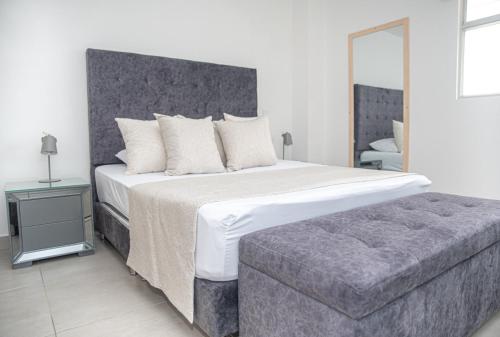 a bedroom with a large bed and a couch at Ginebra central laureles estadio in Medellín