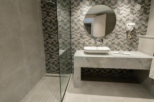 a bathroom with a sink and a mirror at Hôtel Hammamet Beach in Hammamet