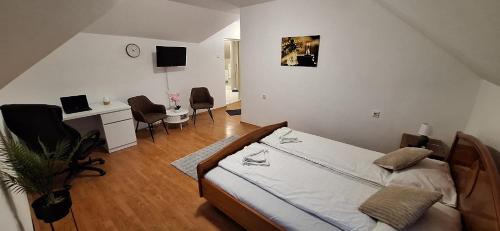 a bedroom with a bed and a desk with a computer at The HOME in Ditrău