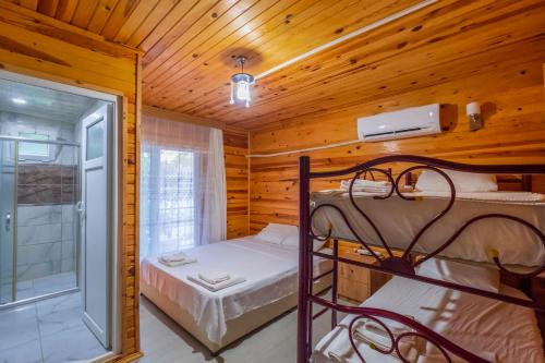 a bedroom with two bunk beds in a wooden cabin at Adrasan Çıtır Pansiyon in Kumluca