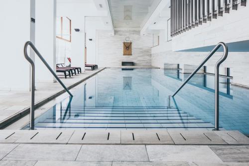 - une piscine avec des escaliers dans un bâtiment dans l'établissement The Crystal VAYA Unique, à Obergurgl