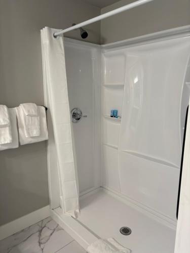 a white bathroom with a shower with a glass door at Deep Water Inn in Chelan