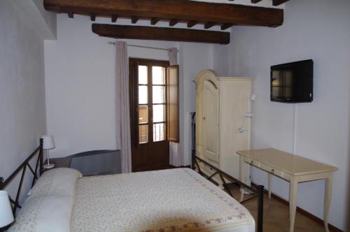 a bedroom with a bed and a table and a window at Roby's House in Gaiole in Chianti