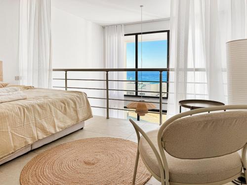 a bedroom with a bed and a table and a chair at LUKA Duplex SeaView and Terrace in Aglantzia