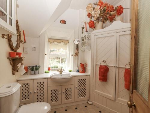 a bathroom with a sink and a toilet and a window at White Heather Cottage in Killaloe