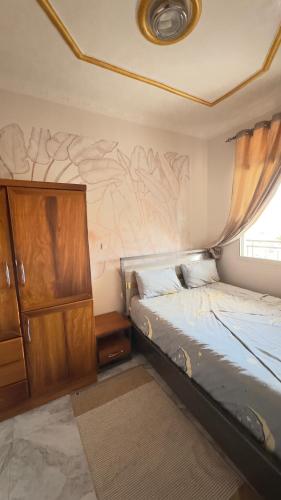 a small bedroom with a bed and a dresser at Etoile de Nathalice in Kinshasa