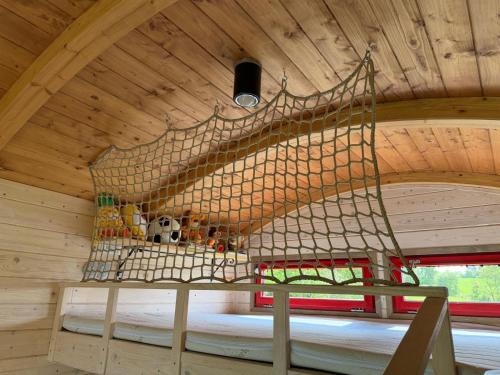 a room in a tree house with a net at Maringotka Květuška ubytování na farmě in Pulečný