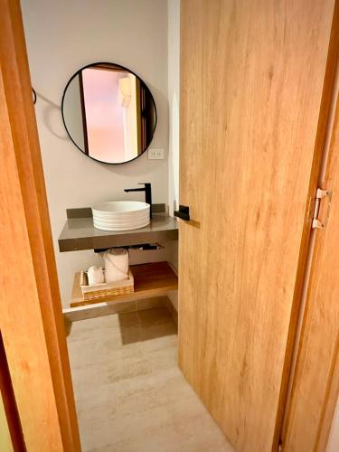 a bathroom with a mirror and a shelf with plates at Cumaé Hotel Boutique in Quimbaya