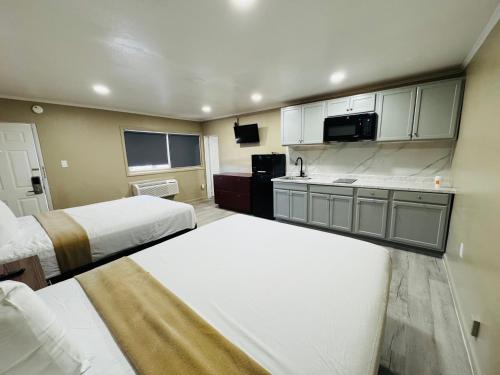 a hotel room with two beds and a kitchen at AC Suites in Atlantic City
