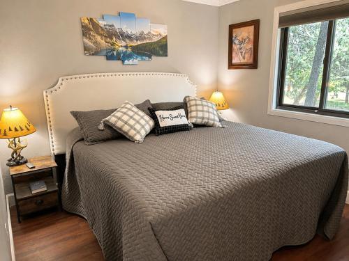 a bedroom with a bed with two pillows on it at Peaceful Pine Place Cabin in Pine