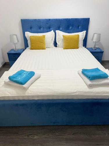 a large bed with blue and yellow pillows on it at The Lighthouse Suite in Mamaia Sat/Năvodari