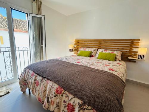 a bedroom with a large bed and a large window at La casa del pinsapo in Yunquera