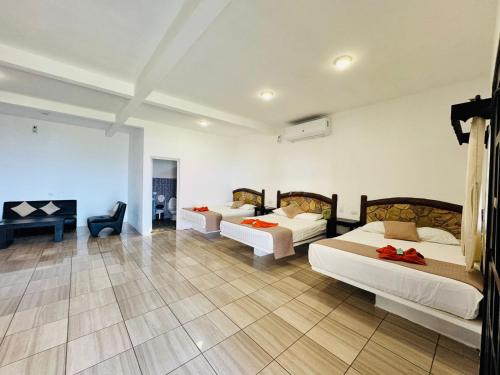 a hotel room with two beds and a desk at Hotel Pazifico en Monterrico in Monterrico