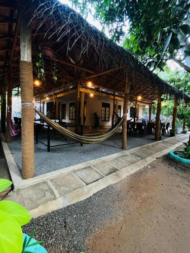 a hammock outside of a building with a restaurant at Hiri Hideout in Dickwella