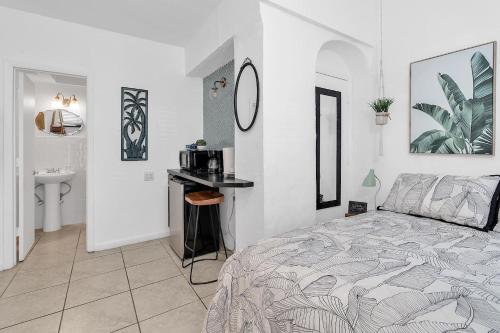 a white bedroom with a bed and a sink at Private Studio in Little Havana in Miami