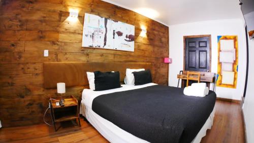 a bedroom with a large bed with a wooden wall at Tremo Bellavista in Santiago