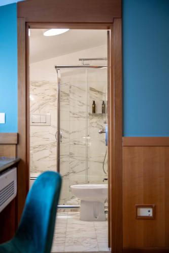 a bathroom with a glass shower and a toilet at Spazio Origine - Studio Hotel in Monopoli