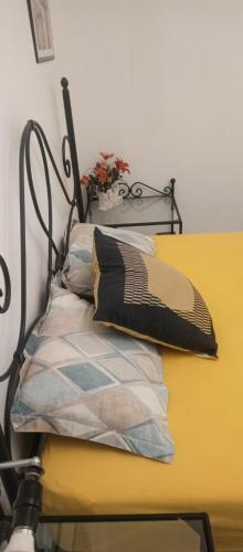 a yellow bed with pillows on top of it at Appartement terrasse climatisée in Tunis