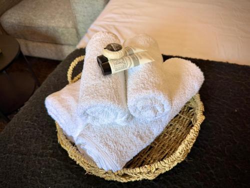 a towel in a basket with a bottle on it at Central Reading Guest House in Reading