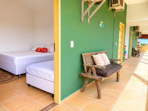 a bedroom with a bed and a chair in a room at Pousada Wilclé Center Preá in Prea