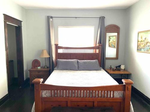 a bedroom with a wooden bed and a window at Private room in the Heart of Little Havana for 4 Guests in Miami