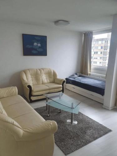 a living room with a couch and a table and a bed at Messewohnung-Monteurwohnung Dormagen in Dormagen