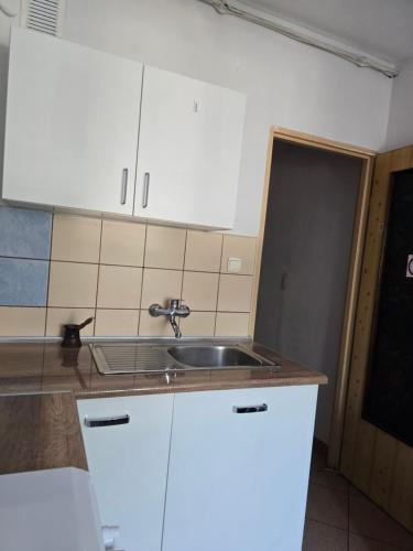 a kitchen with white cabinets and a sink at Home 24 check-in in Poznań